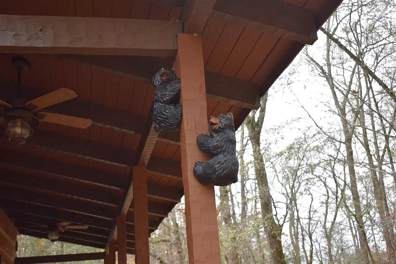 A wooden structure with a ceiling fan and a bear statue.