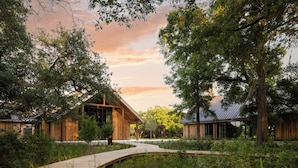 A wooden building with large windows and a curved wooden pathway leading to it. - The Dunlin, Auberge Collection (Johns Island)