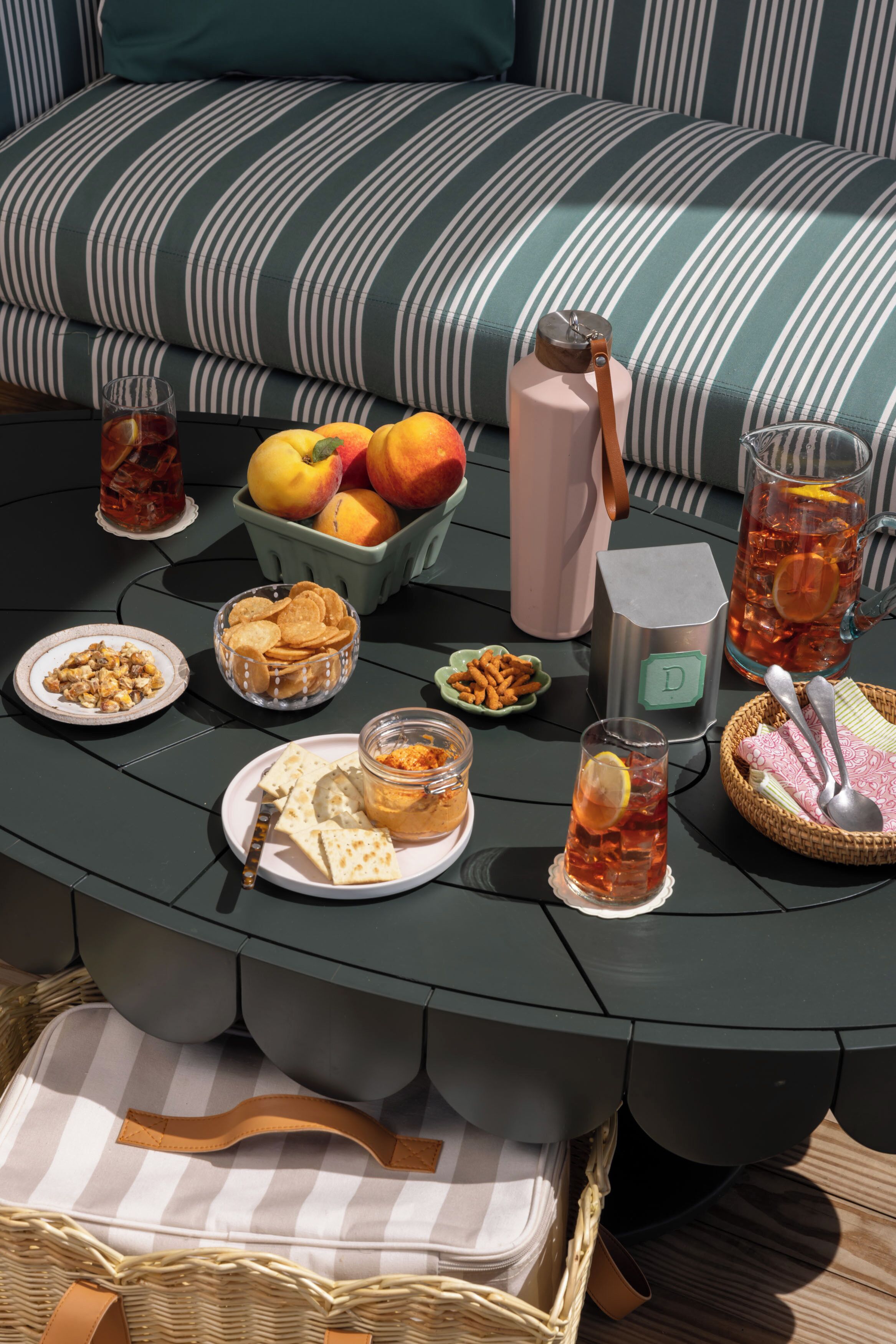 A round table with various food items, drinks, and a water bottle.