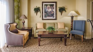 Una sala de estar con sofá, sillón, mesa de centro y dos lámparas de pared.