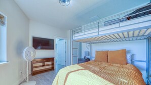 A bedroom with a bunk bed, a bedside table, a fan, and a TV. - The Jolly Rancher, Luxury Amenities, Corporate and Vaca (Twin Falls)