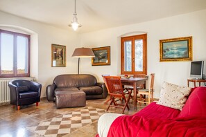 Un salon comprenant un canapé, un fauteuil, une table à manger et des chaises.