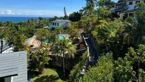 Un quartiere residenziale con piscina, palme e vista sull'oceano.