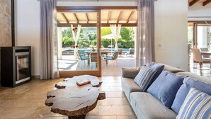 Un salon moderne avec une table basse en pierre, un canapé orné de coussins à rayures et une cheminée.