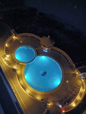 Una piscina circular con una isla central y una pequeña construcción en la parte superior.