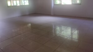 A spacious room with a tiled floor and two windows with white frames.