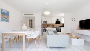 A modern apartment with a dining area, kitchen, living room, and a TV. - Palazzio Re-2753-Modern apartment close to the Port (Cannes)