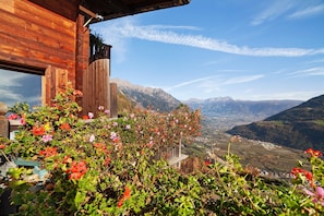 Ein Holzbau mit Blick auf Berge und ein Tal.