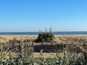 A beach with a sandy foreground, a wooden structure, and the ocean in the background. - Holiday Home 'Casa Costella, Saint Pierre La Mer' with Sea View, Private Terrace and Private Garden (Fleury)