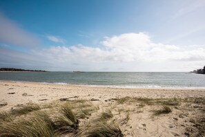 A beach with sand, grass, and a clear sky. - Mobile Home 'Au Petit Bonheur' with Shared Pool, Private Terrace and Private Garden (Carnac)