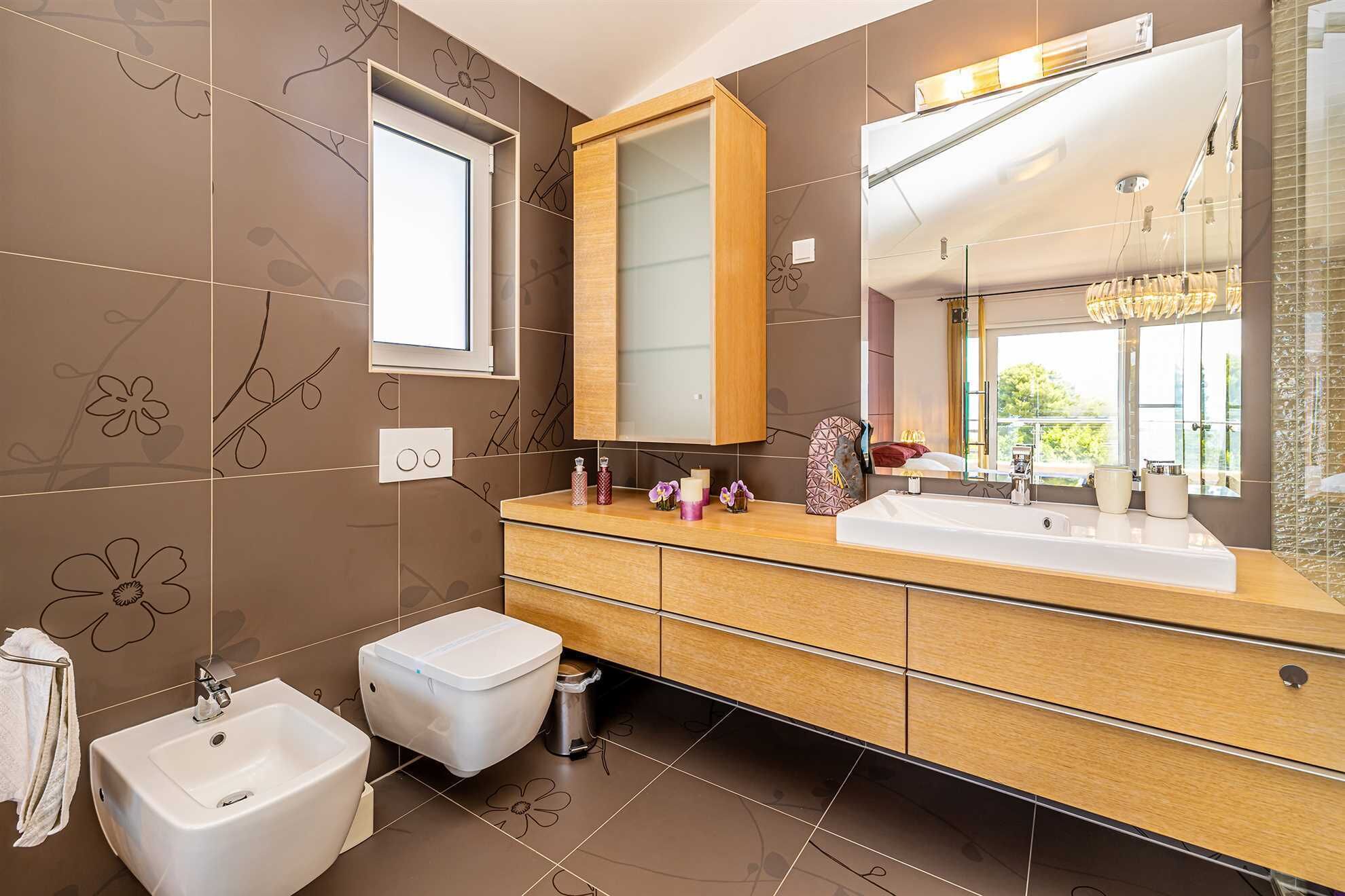 Ein modernes Badezimmer mit einem Doppelwaschtisch, einer Toilette und einem Bidet.