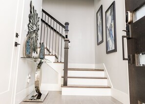 A staircase with a modern design, featuring a metal railing and a wooden finish. - Houston Lux Townhome (Houston)