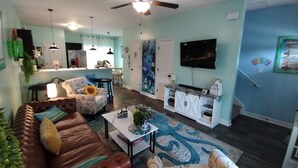 A living room with a brown leather sofa, a white coffee table, and a patterned rug. - Beachy style and cosy. Book your own little hotel.No pet FEE, 4 Guests. (Sneads Ferry)
