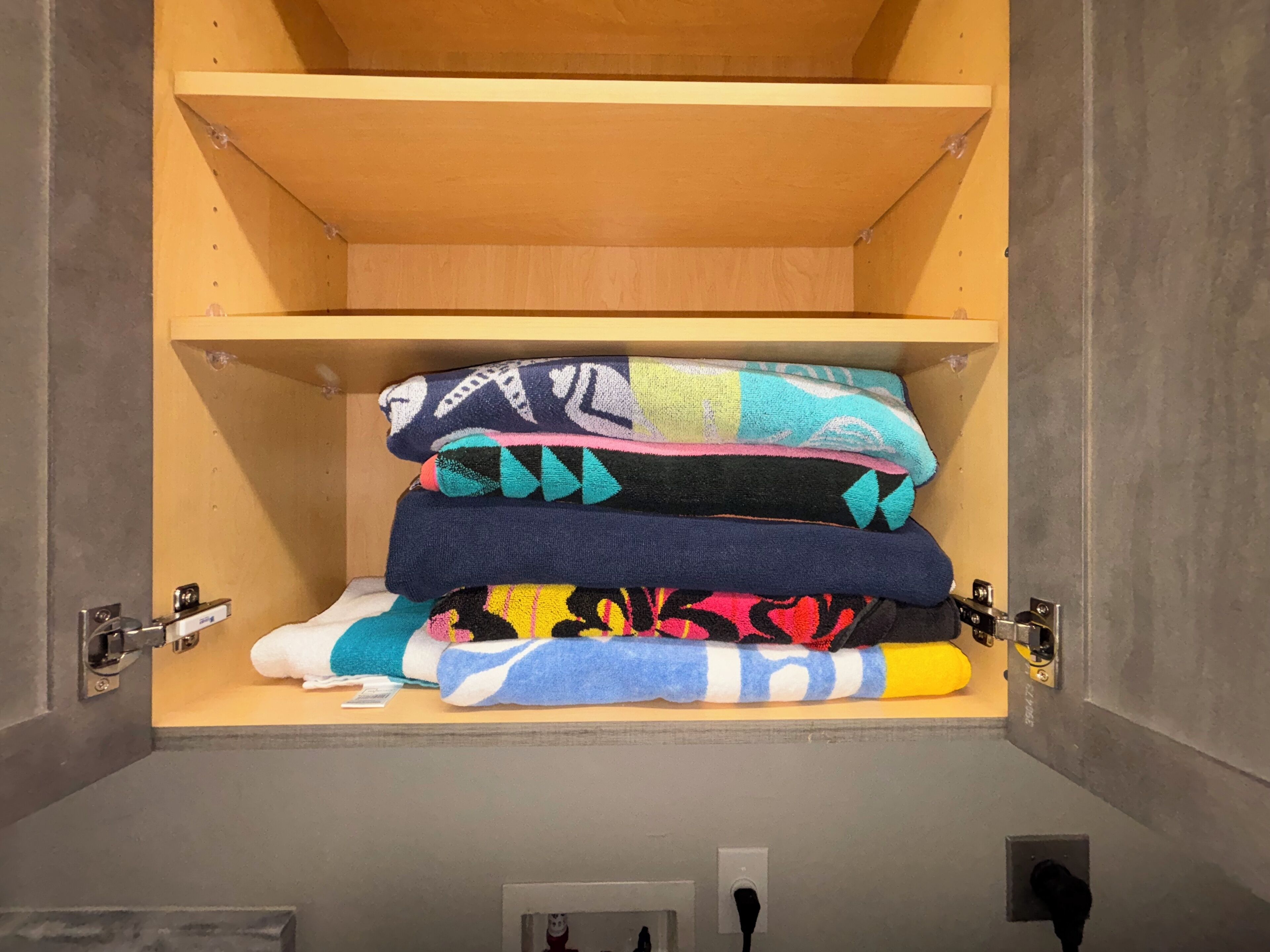 A storage unit with multiple shelves holding folded blankets and towels.