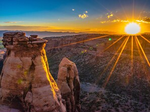 A rock formation with a flat top and a steep drop-off, surrounded by a desert landscape with sparse vegetation. - Rabbitbrush: Trail Access at Your Door (Grand Junction)