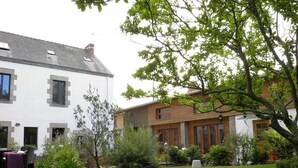 Een huis met twee verdiepingen, een verzorgd gazon en tuin.