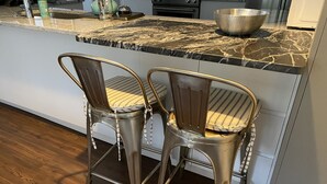 A kitchen with two metal chairs, a marble countertop, and a wooden floor. - Little Farm: Private Country Setting, 15 minute drive to downtown Aiken (Aiken)