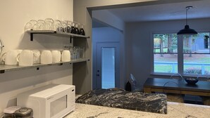 A kitchen with a microwave, shelves with glassware, a marble countertop, and a view of the outdoors. - Little Farm: Private Country Setting, 15 minute drive to downtown Aiken (Aiken)