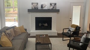 A living room with a fireplace, a ceiling fan, a sofa, and two armchairs. - Little Farm: Private Country Setting, 15 minute drive to downtown Aiken (Aiken)