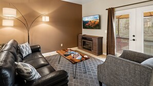 Ein Wohnzimmer mit Kamin, Ledersofa und Couchtisch mit Zeitschriften.