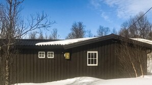A dark wooden cabin with a sloped roof, two windows, and a chimney. - 3 bedroom stunning home in Uvdal (Uvdal)