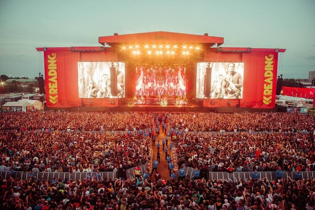 A large outdoor concert stage with a crowd in front.