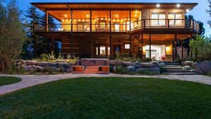A large, multi-level wooden house with a covered porch and outdoor seating area. - Casa Del Rio hot tub, sauna, movie theater #020796 (Buena Vista)