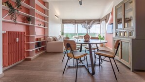 A modern kitchen with a dining area, featuring a round table, chairs, and a ceiling fan. - Viola Penthouse with Rome Panoramic View (ROMA)