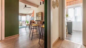 A modern living room with a dining area, a ceiling fan, and a view of the balcony. - Viola Penthouse with Rome Panoramic View (ROMA)