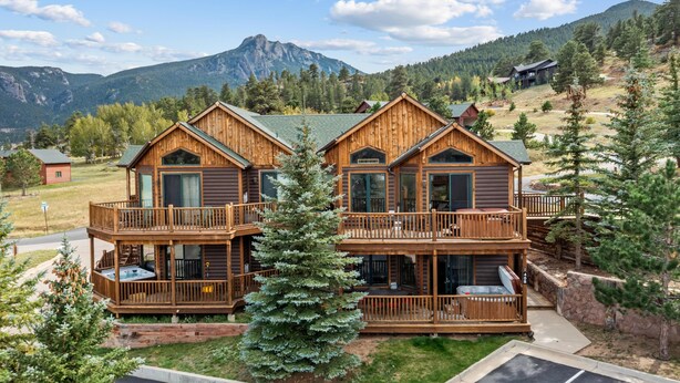 A wooden cabin with a balcony and a mountain view.