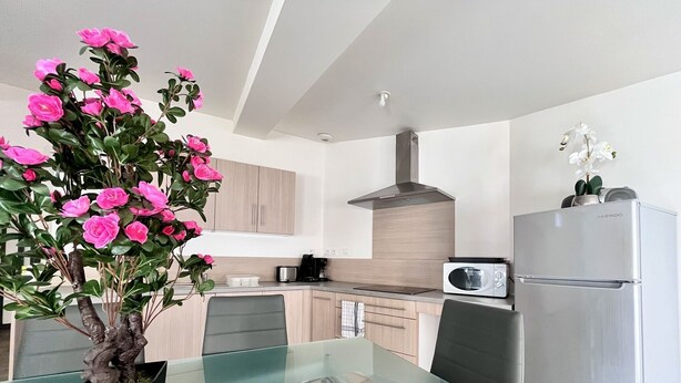 A modern kitchen with a glass dining table, a stainless steel refrigerator, and a microwave. - Chez Isa - Tournon-sur-Rhône (Tournon-sur-Rhône)