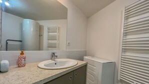 A bathroom with a sink, mirror, towel rack, and a radiator. - Chez Isa - Tournon-sur-Rhône (Tournon-sur-Rhône)
