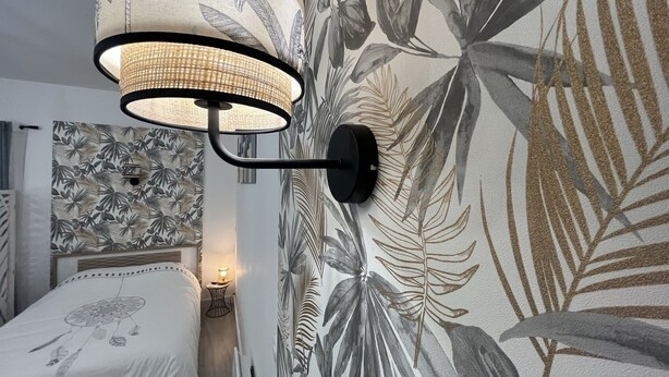 A bedroom with a bed, a wall-mounted lamp, and a floral wallpaper. - El Castillo - Tournon-sur-Rhône (Tournon-sur-Rhône)