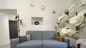 A modern living room with a grey sofa, decorative pillows, a bonsai tree, and white orchids. - El Castillo - Tournon-sur-Rhône (Tournon-sur-Rhône)