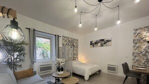 A modern, well-lit living area with a sofa, a dining table, and a bed. - El Castillo - Tournon-sur-Rhône (Tournon-sur-Rhône)