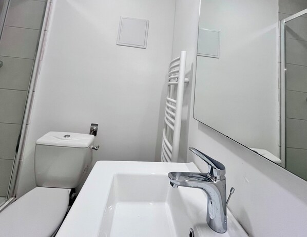 Ein Badezimmer mit Waschbecken, Spiegel und Toilette.