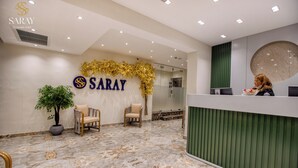 A reception area with a marble floor, a reception desk, and a wall-mounted sign for 'SARAY'. - Saray Pyramids & Museum View Hotel (Giza)