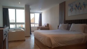 A modern hotel room with a large bed, a desk, a chair, and a bathtub. - Saray Pyramids & Museum View Hotel (Giza)