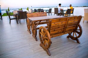 Enjoy dining or socializing on this waterfront deck with a long bench and comfortable seating.