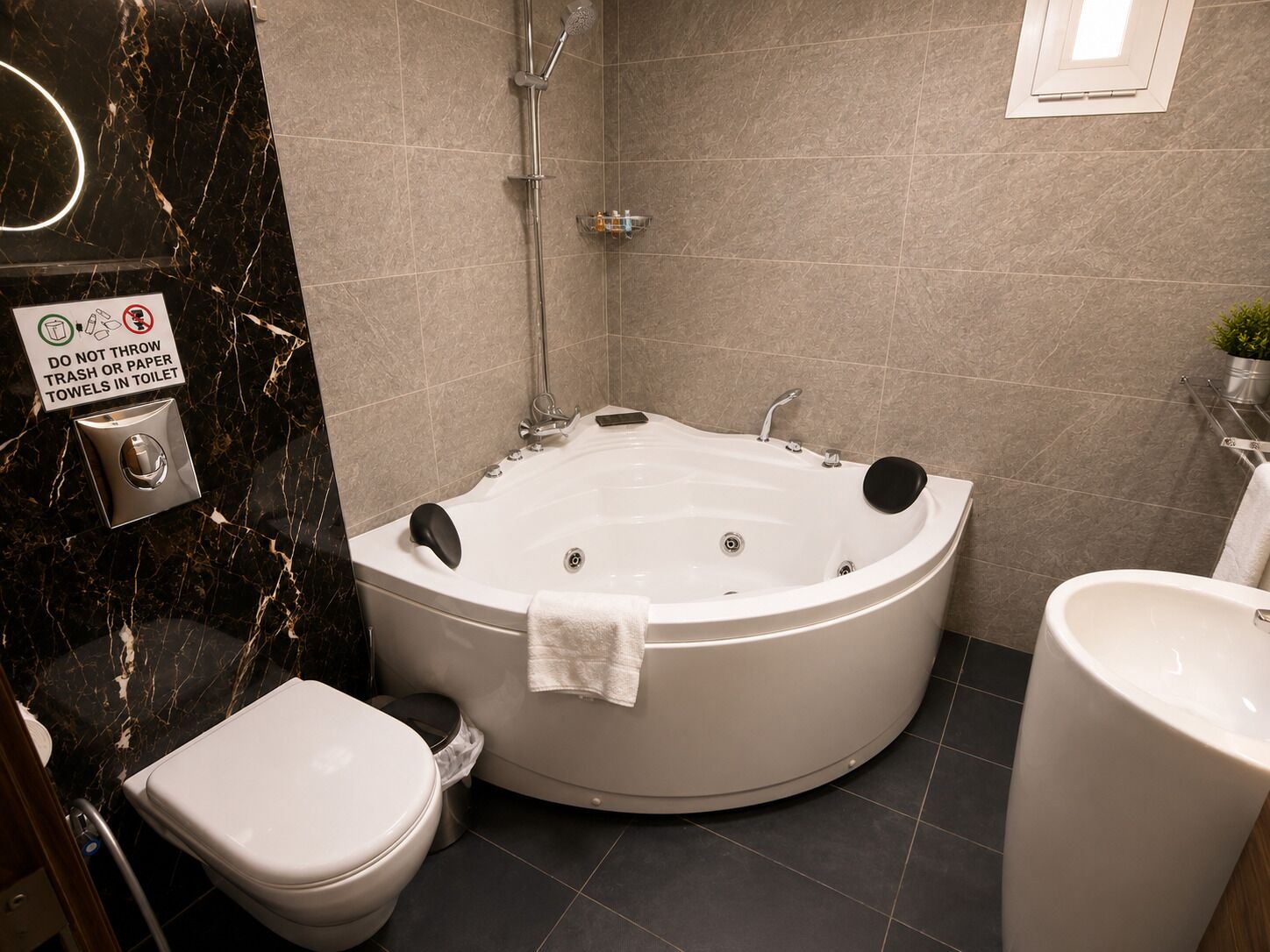 Un baño con una bañera grande, inodoro y lavamanos.