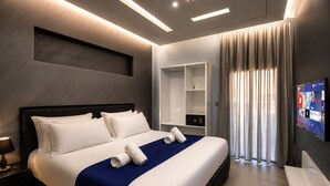 A modern hotel room with a large bed, a built-in TV, a bedside table, and a wardrobe. - Matar Residence Hotel Suites (Sabtiyeh)