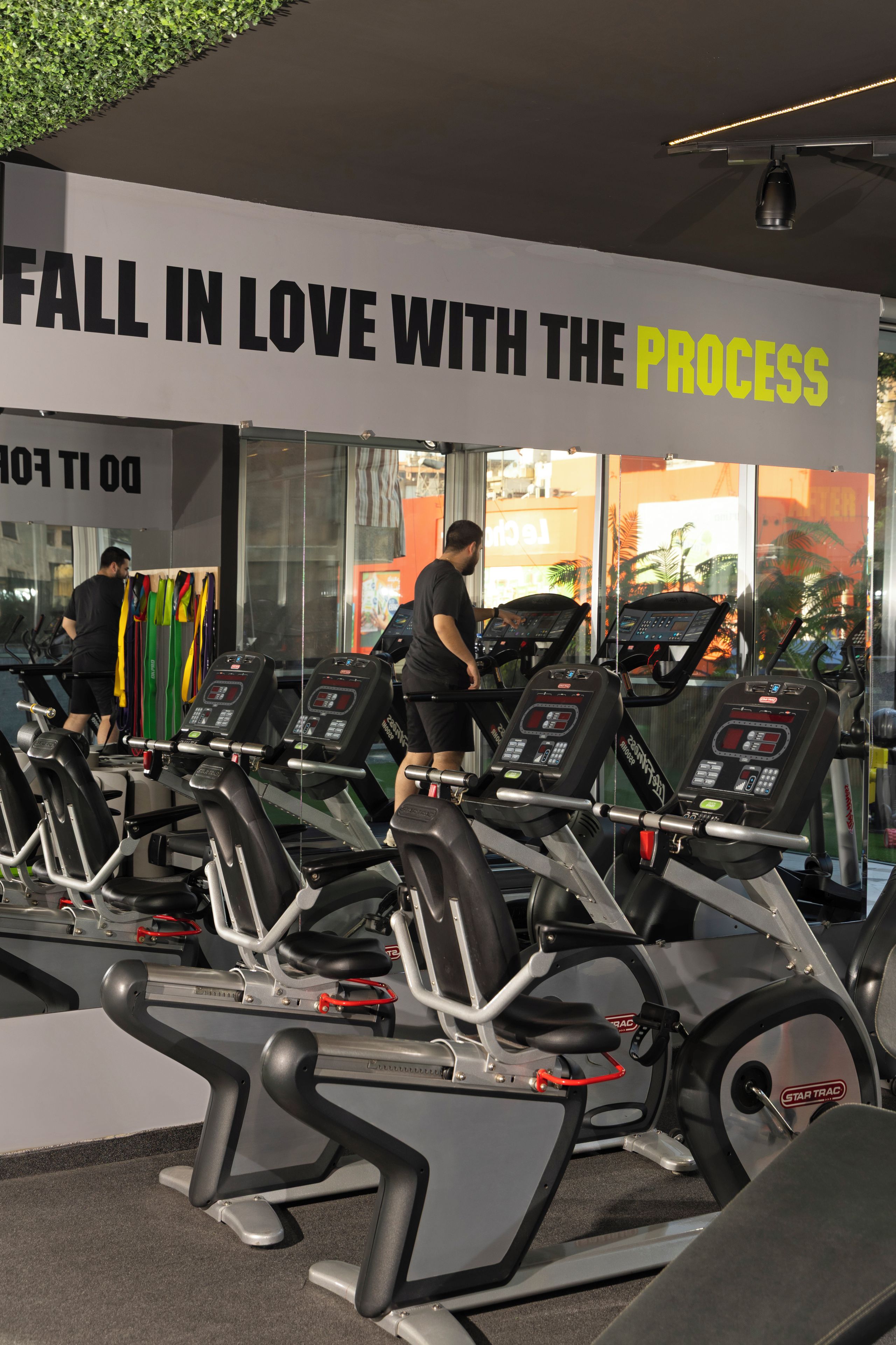A gym with treadmills and a motivational sign.