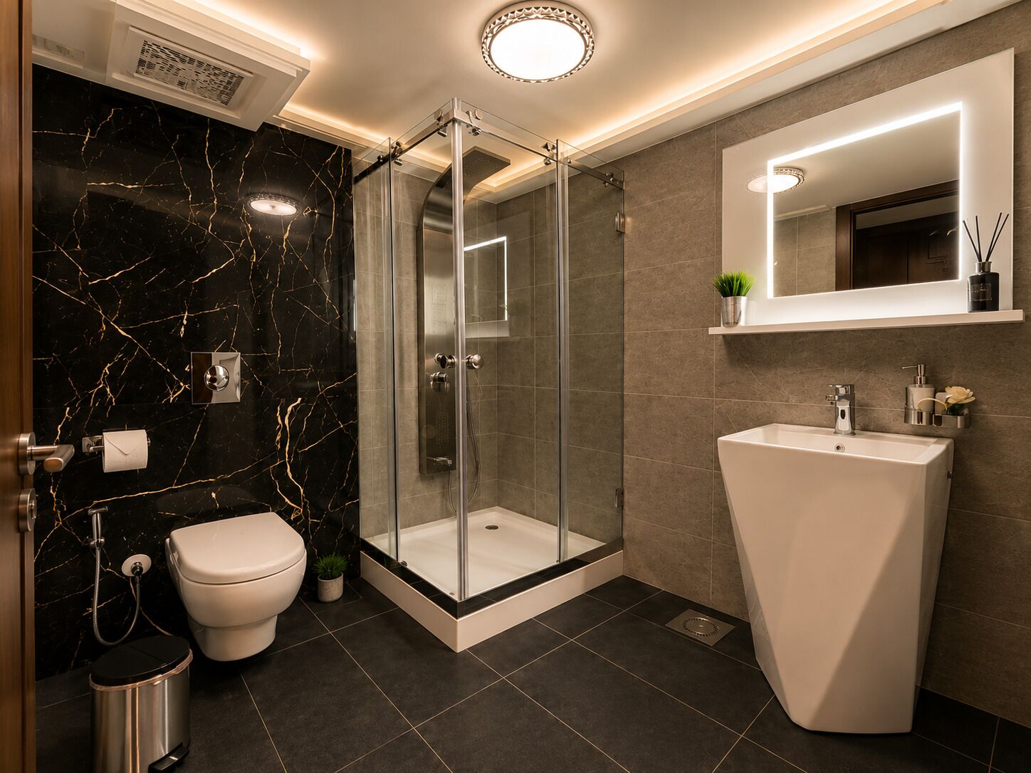 Un bagno moderno con cabina doccia in vetro, lavandino bianco e parete rivestita in marmo.