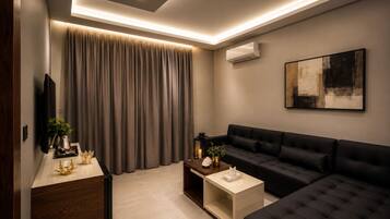 Suite junior, 1 cama matrimonial | Área de sala de estar | Smart TV de 45 pulgadas con canales digitales
