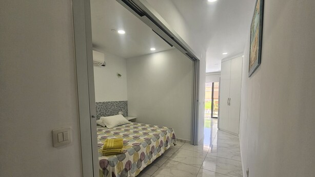 Una camera da letto con un letto, un comodino e un bagno dotato di doccia.