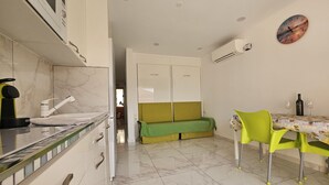 Una cucina compatta con fornelli moderni, un lavello e un'area pranzo con tavolo e sedie.