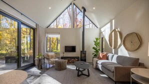 Ein modernes Wohnzimmer mit großem Fenster, Kamin und einer Couch.