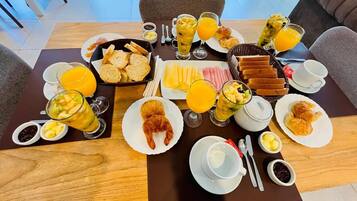 Um buffet de café da manhã com diversos alimentos e bebidas.