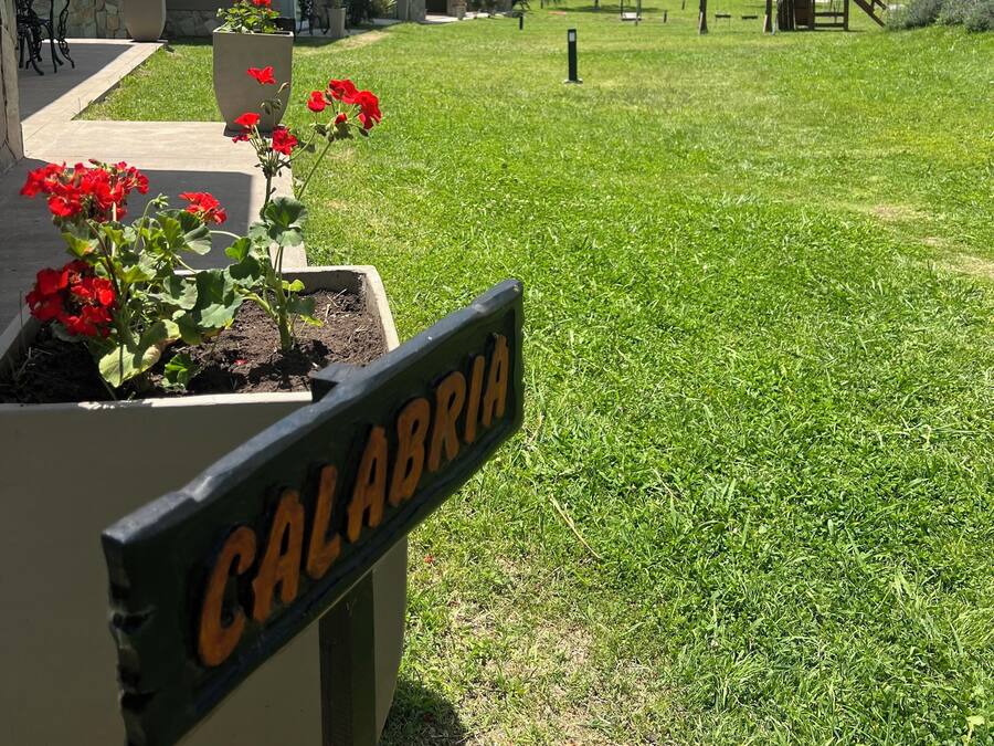 Zona residenziale con un cartello che riporta la scritta 'Calabrin' in un vaso da fiori.