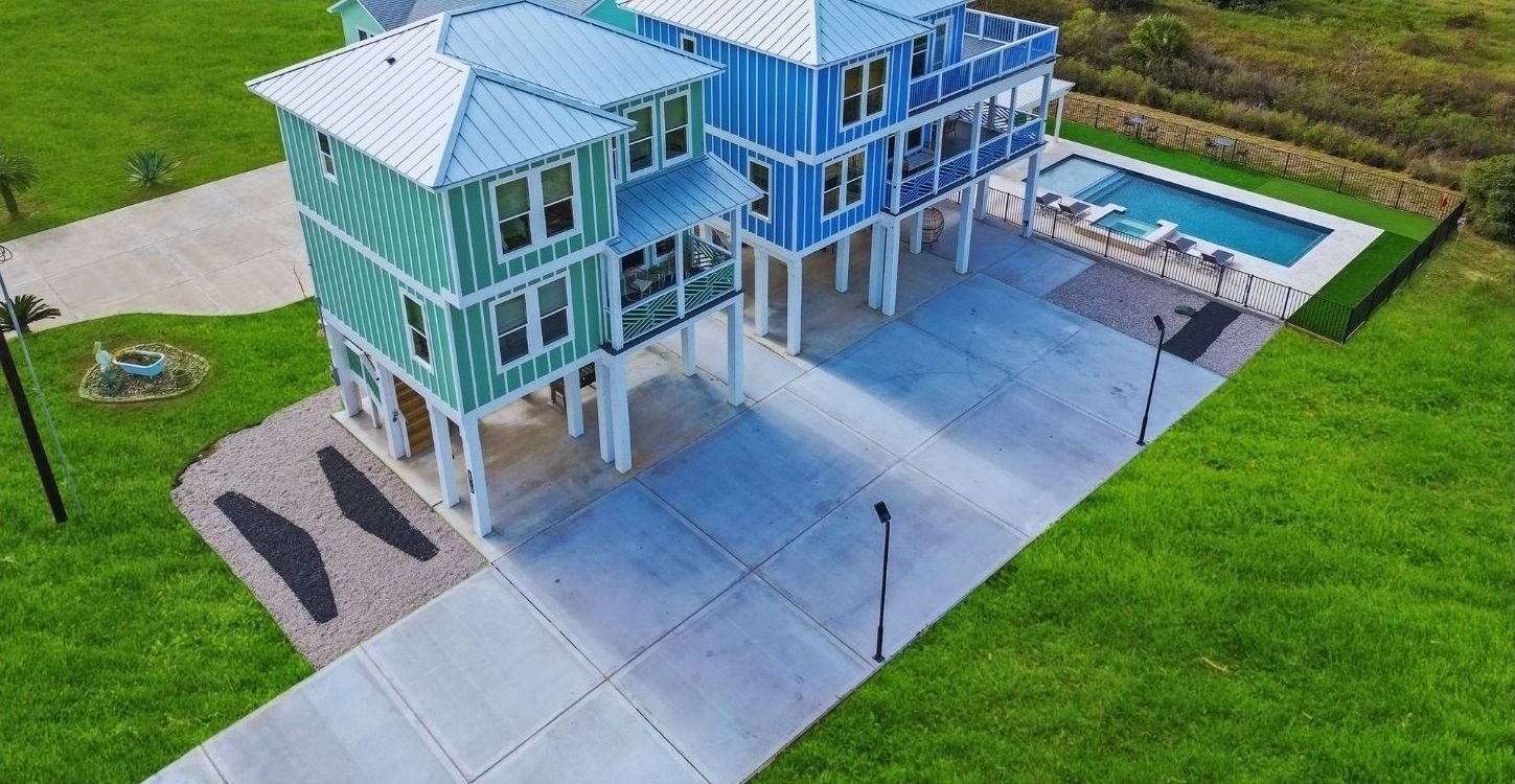 A green house with a pool and a tennis court.